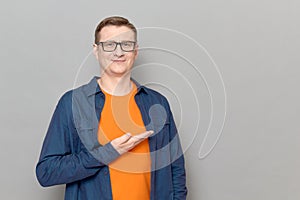 Portrait of happy man pointing with one hand at copy space and smiling