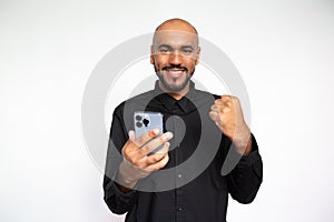 Portrait of happy man with smartphone making winning gesture