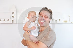 Portrait of a happy man smiling and holding cute baby