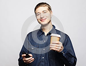 Portrait of happy man talking on phone and drinking coffee