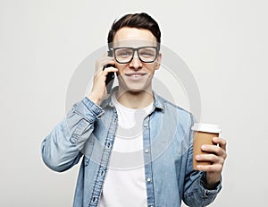 Portrait of happy man talking on phone and drinking coffee