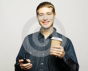 Portrait of happy man talking on phone and drinking coffee