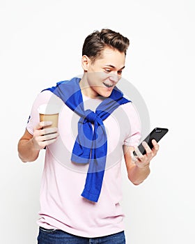 Portrait of happy man talking on phone and drinking coffee