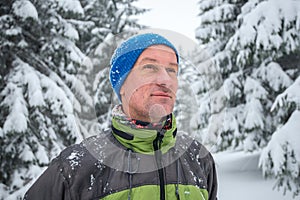 Portrait of happy man traveler in the winter mountains