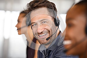 Portrait of happy mature customer service man on call