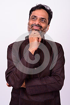Portrait of happy mature handsome bearded Indian businessman
