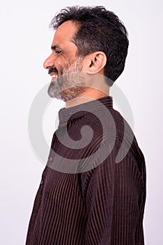 Portrait of happy mature handsome bearded Indian businessman
