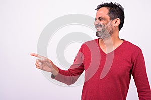 Portrait of happy mature handsome bearded Indian man