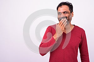 Portrait of happy mature handsome bearded Indian man