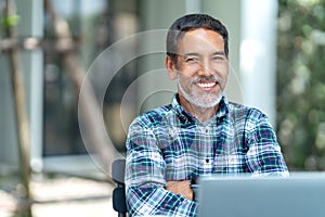 Portrait of happy mature man with white, grey stylish short beard looking at camera outdoor. Casual lifestyle of retired hispanic