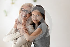 Portrait of happy mature mom and adult daughter hugging