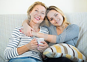 Portrait of happy mature mother and young daughter at home