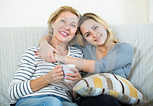 Portrait of happy mature mother and young daughter at home