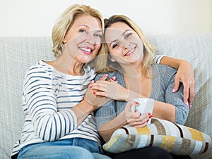 Portrait of happy mature mother and young daughter at home