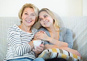 Portrait of happy mature mother and young daughter at home