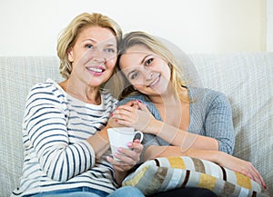 Portrait of happy mature mother and young daughter at home