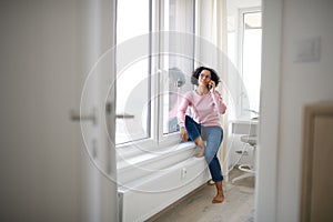 Portrait of happy mature woman making a phone call indoors.