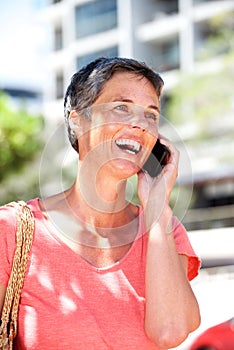 Happy mature woman talking on mobile phone outdoors