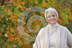 Portrait of a happy mature woman with warm pullover in nature