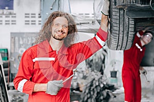 portrait happy mechanic garage staff worker enjoy car service. tire replace in garage auto workshop