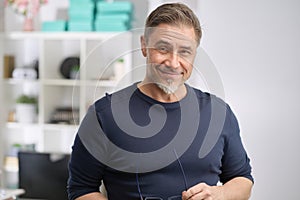 Portrait of happy middle aged casual man at home smiling