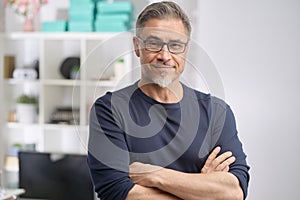 Portrait of happy middle aged casual man at home smiling