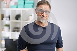 Portrait of happy middle aged casual man at home smiling