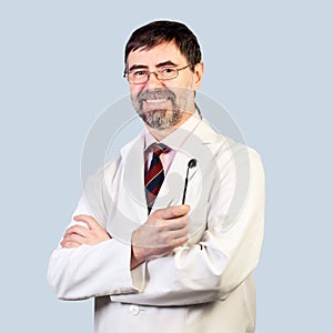 Portrait of happy middle-aged dentist on a pale background, wear