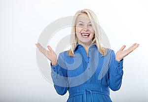 Portrait of happy middle aged woman. Surprised happy woman looking with her mouth open and holding her arms out in