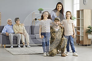 Portrait of happy military veteran together with his family upon returning back home