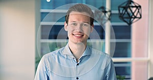 Portrait of happy millennial businessman posing in modern corporate office