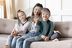 Portrait of happy mom with kids relax on sofa
