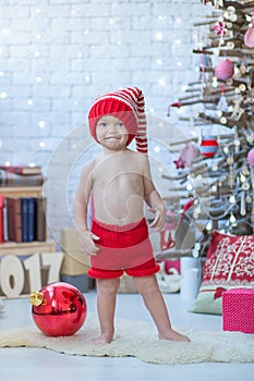 Portrait of happy mother and adorable baby celebrate Christmas. New Year`s holidays. Toddler with mom in the festively decorated r