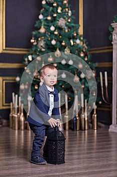 Portrait of happy mother and adorable baby celebrate Christmas. New Year`s holidays. Toddler with mom in the festively decorated r