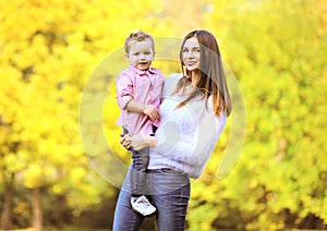 Portrait happy mother and child in autumn park