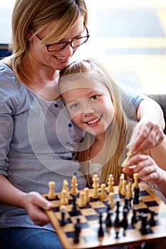 Portrait, happy and a mother and child with chess for education, strategy and teaching a game. Smile, family and a girl