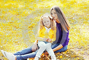 Portrait happy mother with child together in warm sunny autumn