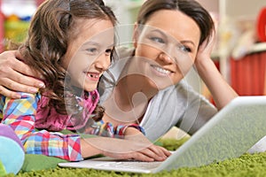 Portrait of happy mother and daughter using laptop