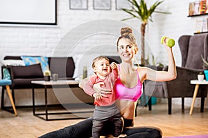 Mother exercising with her baby son at home