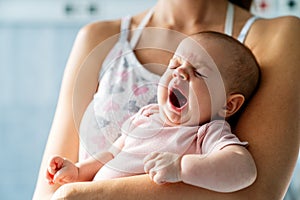 Portrait of a happy mother with her tired newborn baby. Family love concept