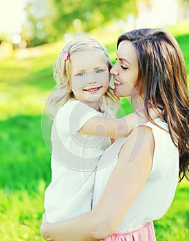 Portrait happy mother hugging child daughter in summer