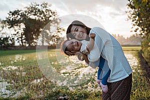 A portrait of a happy mother hugging her child in the rice fields