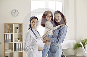 Portrait of happy mother and little child with their pediatrician or family doctor