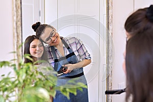 Portrait of happy mother and teenage daughter at home together