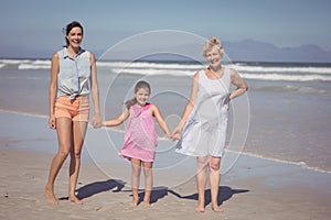 Portrait of happy multi-generation family holding hands at beach
