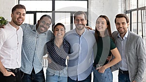 Portrait of happy multiracial colleagues posing together in office