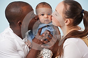 Portrait of happy multiracial family against pale blue background