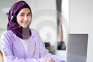 Portrait of happy Muslim women wearing hijab customer support phone operator at workplace. Professional operator concept