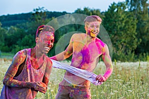 Happy muticultural men with colorful paint on bodies at holi festival