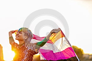 Portrait of happy non-binary person waving gender fluid flag